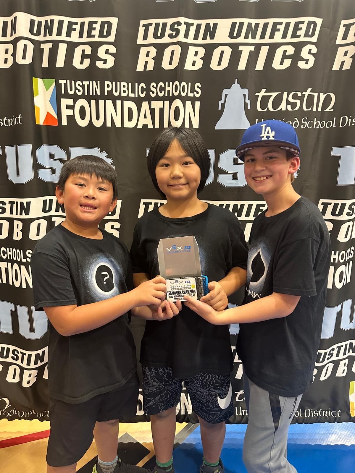 Young Edubot students holding the robot they built